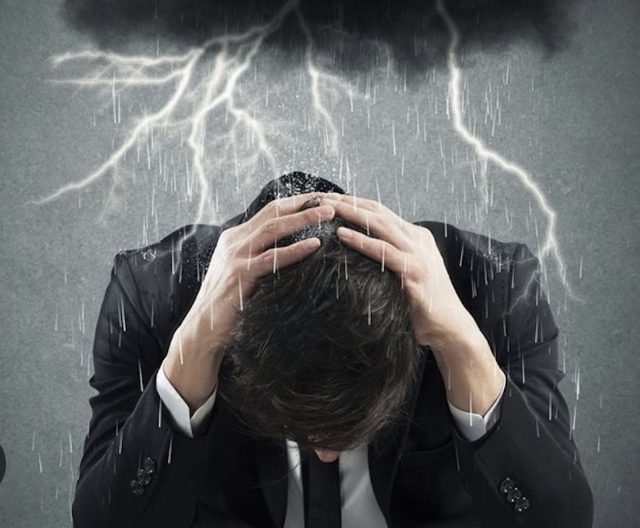 Un homme se tient la tête sous un nuage noir lui projetant des énergies négatives.
